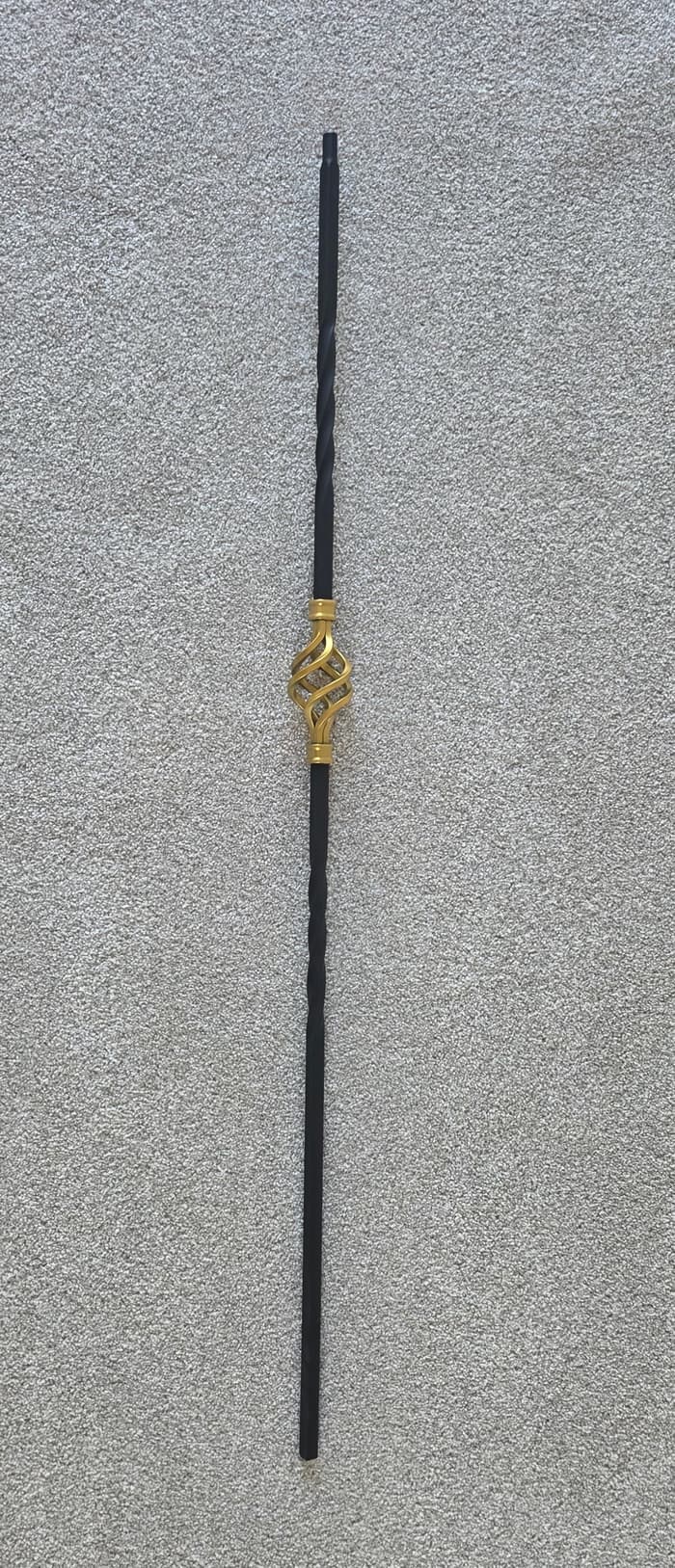 Close-up of the Q-104 Gold Basket spindle finish on carpeted staircase